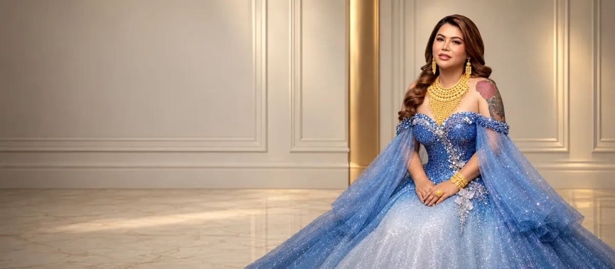 Miss Kim in a blue gown wearing gold jewellery